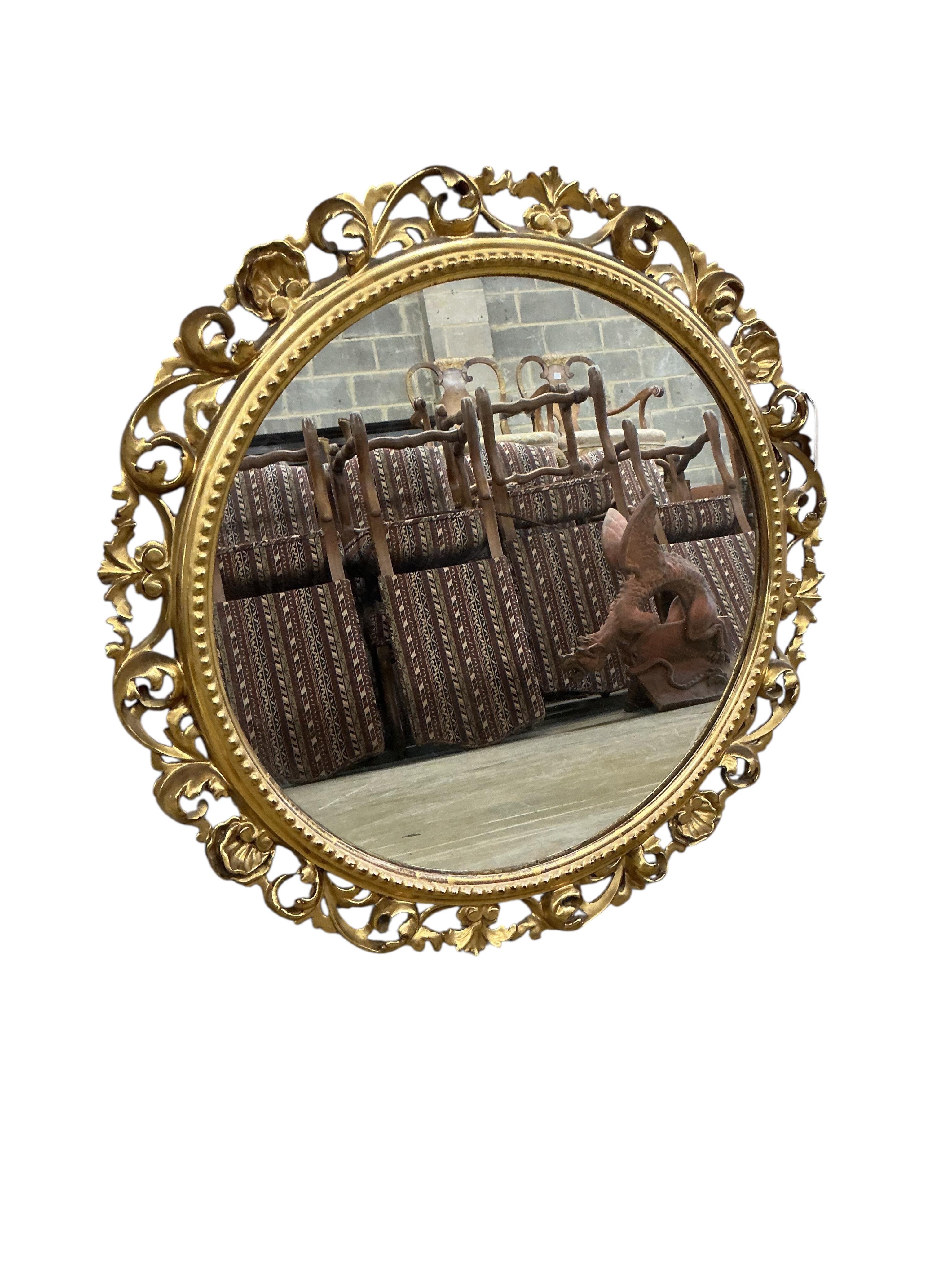 A Florentine style circular carved giltwood and composition wall mirror, diameter 63cm